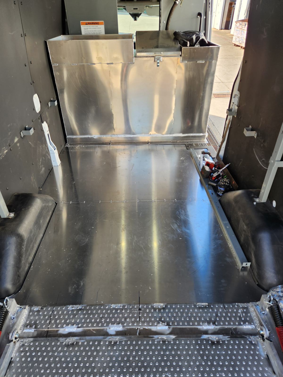 Van interior with aluminum floor and integrated tank