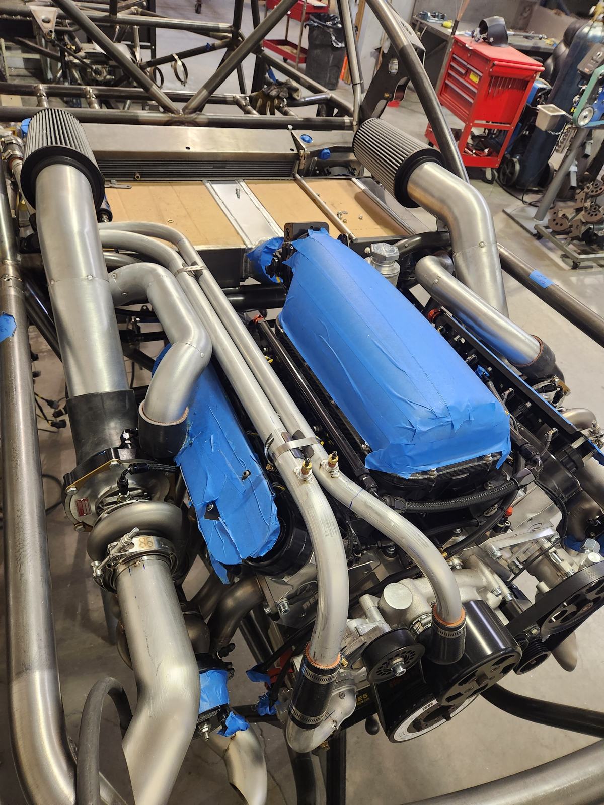 Custom turbo and intake piping in a tube-frame engine bay